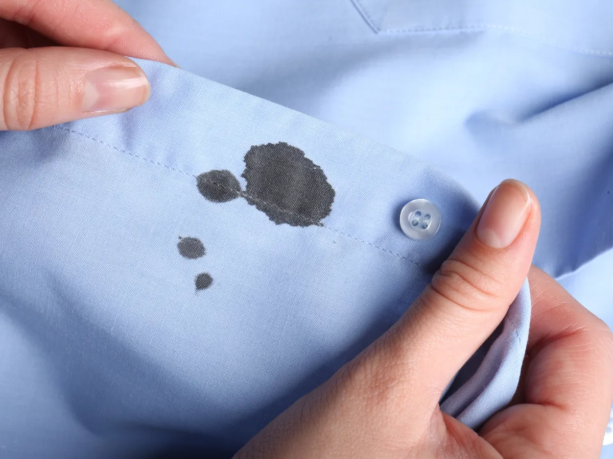 Mancha de tinta de bolígrafo azul en el bolsillo de una camisa blanca