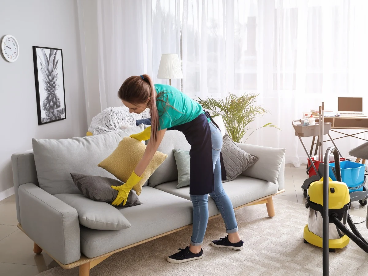 Close-up of a fabric sofa corner with mold stains being cleaned