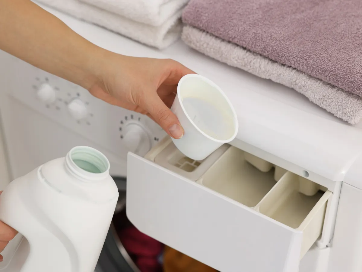Open washing machine drawer showing different compartments for detergent and additives