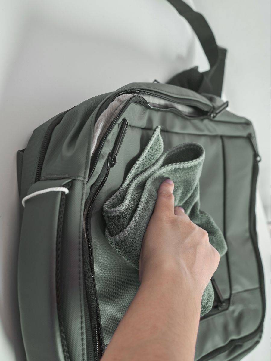Hand washing a backpack with a soft brush and soapy water