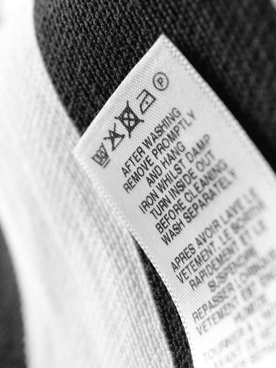 Revisando la etiqueta de lavado de una prenda delicada