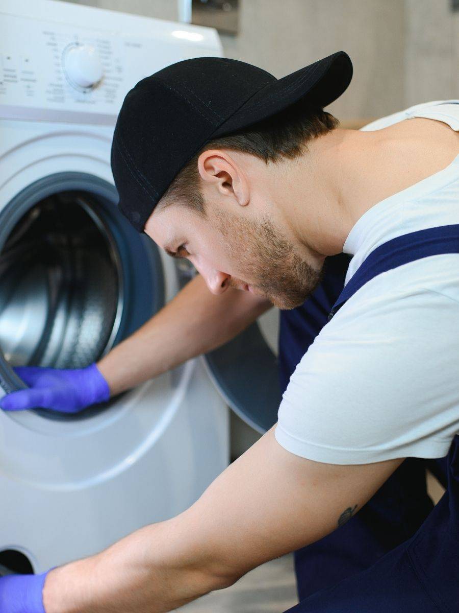 Adjusting the leveling feet of a washing machine with a wrench