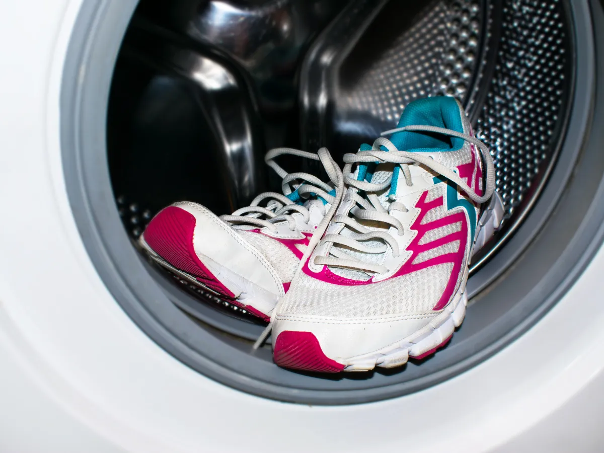 White sports sneakers inside a mesh bag, ready to go into the washing machine