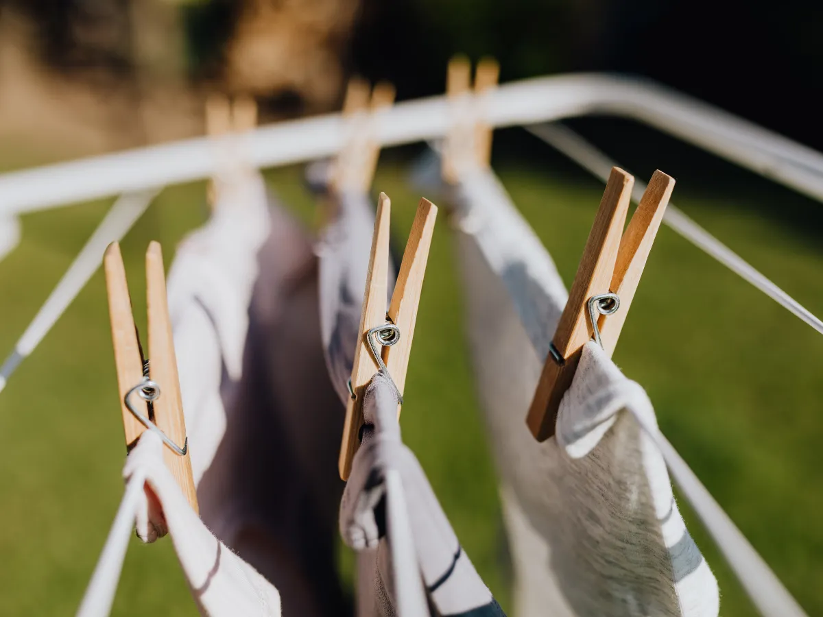 Tendedero extensible lleno de ropa blanca al sol