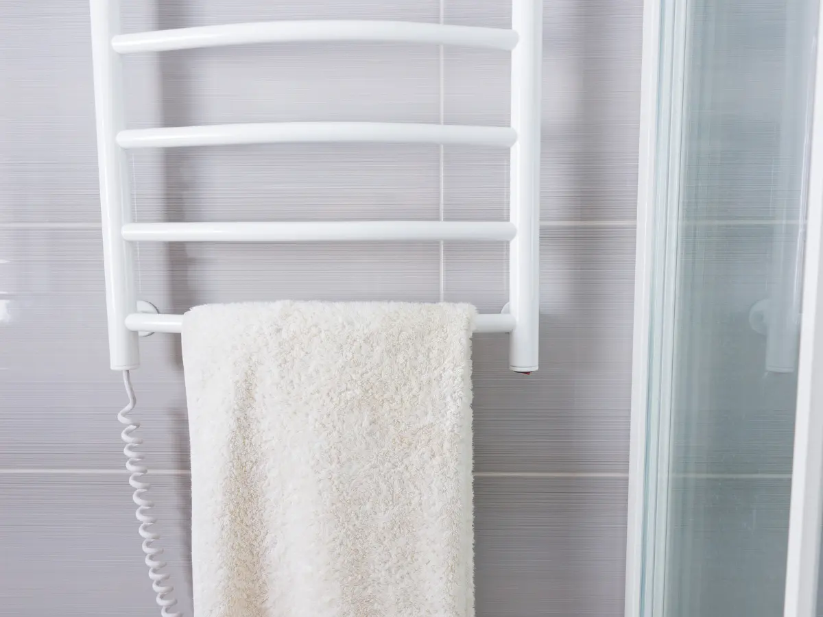 Modern electric towel warmer in a minimalist bathroom
